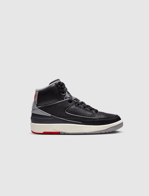 Black and grey high-top sneaker with red and ivory accents on a light background