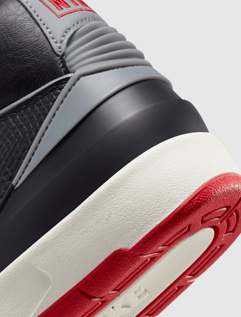Close-up of sneaker heel with black, grey, red, and white color details and textured sole