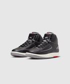 Black and grey high-top sneakers with white and red accents on a plain background