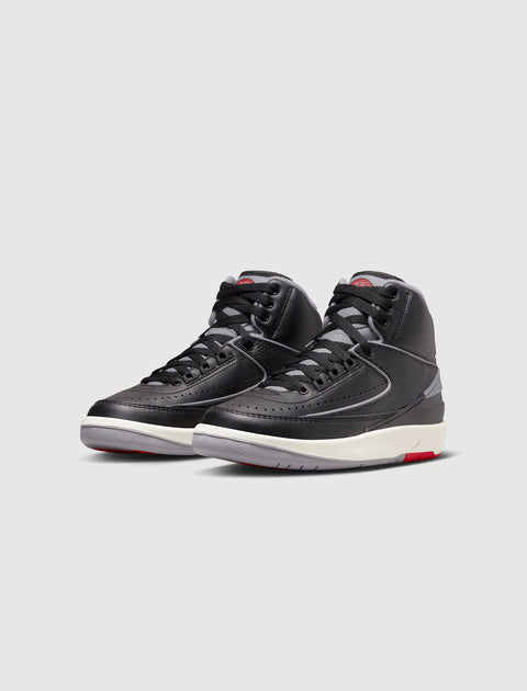 Black and grey high-top sneakers with white and red accents on a plain background