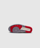 Sole view of sneaker outsole with red, grey, and off-white sections on a light background