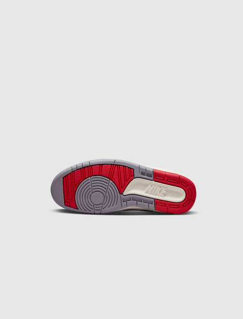 Sole view of sneaker outsole with red, grey, and off-white sections on a light background