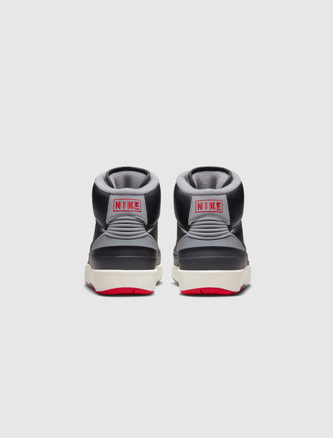 Back view of black and grey high-top sneakers with red NIKE logo and red rubber soles