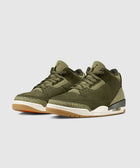 Olive green sneakers with textured midsole, gum outsole, and visible air unit on white background