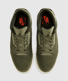 Olive green Nike Air sneakers with red branding and textured midsoles, top view