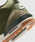Close-up of olive green sneaker heel with textured elephant print and gum sole