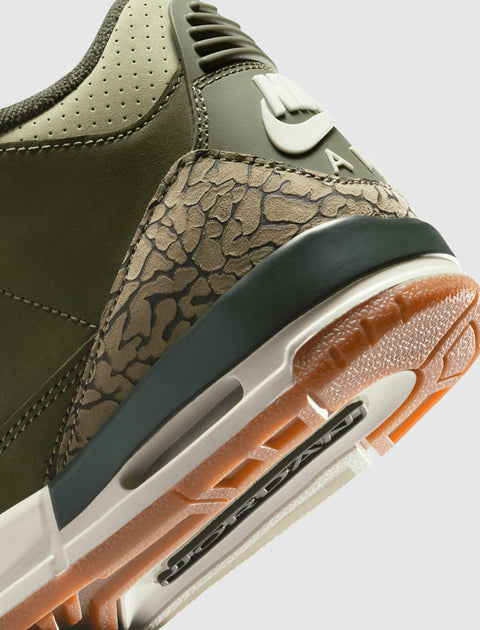Close-up of olive green sneaker heel with textured elephant print and gum sole