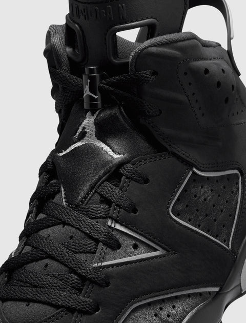 Close-up of black high-top sneaker with perforated panels and embroidered basketball logo