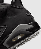 Close-up of black suede and leather sneaker heel with visible air unit and embroidered logo