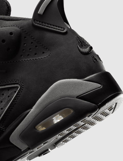 Close-up of black suede and leather sneaker heel with visible air unit and embroidered logo