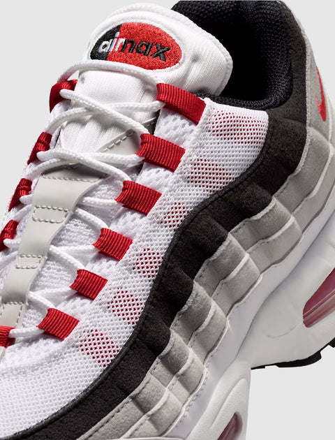 White, red, and grey mesh sneaker with visible air cushioning and bold stitching details