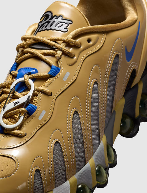 Close-up of tan and mesh men's streetwear sneaker with blue swoosh and unique lace hook.