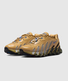 Tan athletic sneakers with mesh panels, wavy detailing, and black sole on white background