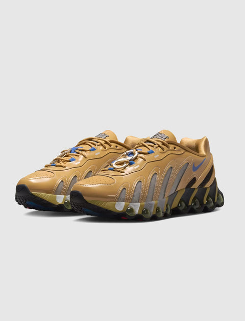 Tan athletic sneakers with mesh panels, wavy detailing, and black sole on white background