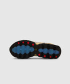 Close-up of sneaker outsole with black, blue, and red tread pattern on light background