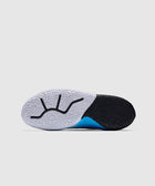 Closeup of sneaker sole with textured black and white pattern and blue accent on a gray background
