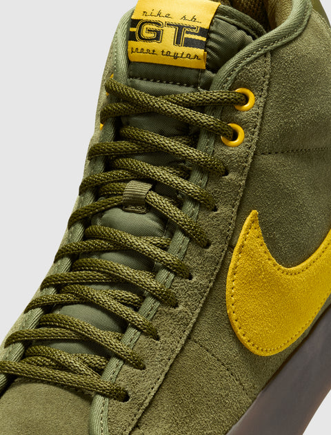 Olive green suede mid-top sneaker with yellow Swoosh and yellow label details