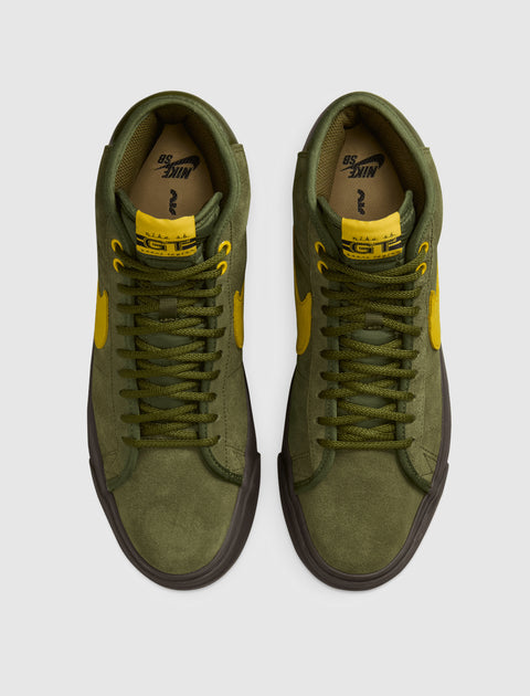 Olive green high-top suede sneakers with yellow accents, viewed from above