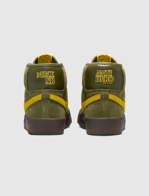 Olive green and yellow suede mid-top skate shoes, rear view, with bold embroidered logos