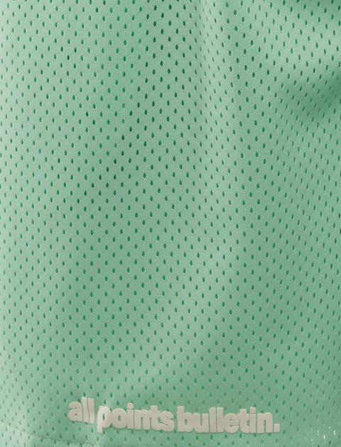 Green mesh athletic shorts with perforated fabric and 'all points bulletin.' text at the hem.