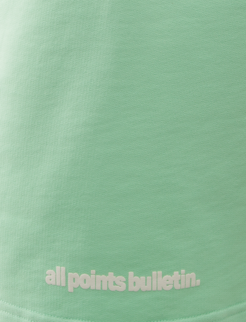 Mint green streetwear top with all points bulletin text in white lettering