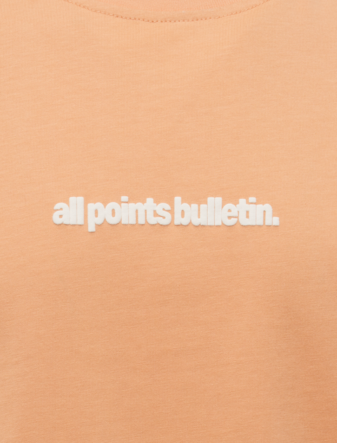 Peach pink streetwear t-shirt with white all points bulletin text embroidered on chest