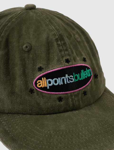 Olive green corduroy baseball cap with colorful embroidered all points bulletin logo and black stars