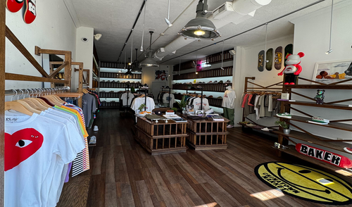 Urban streetwear boutique with graphic tees, sneakers, skateboards, and modern decor
