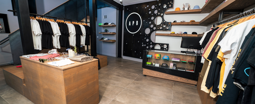 Modern streetwear store interior with men's t-shirts, sneakers, hats, and apparel displays