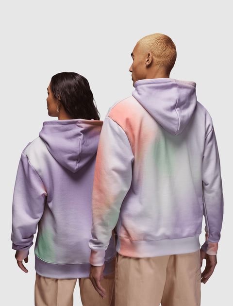 Two people wearing pastel tie-dye hoodies and beige pants, seen from the back
