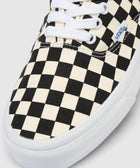Black and white checkerboard low-top sneaker with white laces and rubber sole