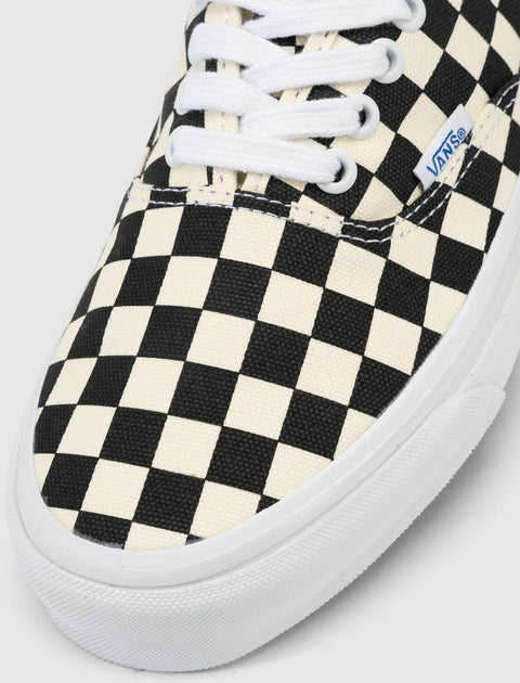 Black and white checkerboard low-top sneaker with white laces and rubber sole