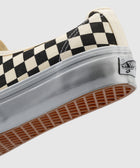 Close-up of black and white checkerboard canvas sneaker with gum sole and rubber trim