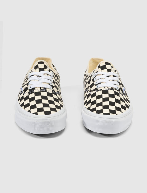 Black and white checkerboard canvas sneakers with white laces and rubber soles