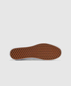 Gum waffle outsole of a classic low-top sneaker on a white background