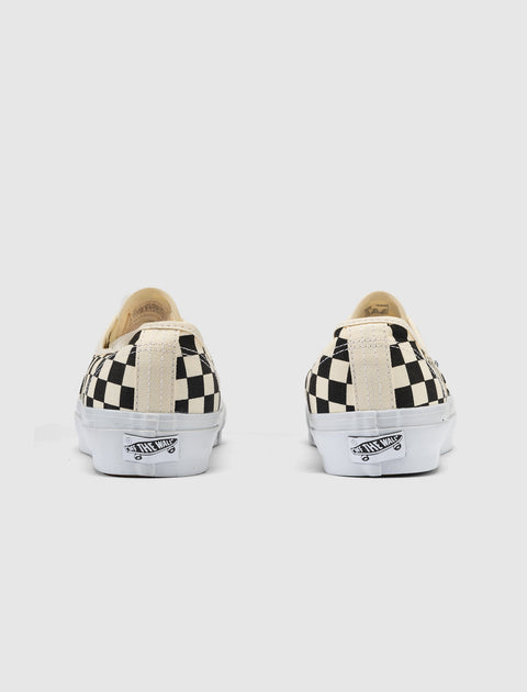 Back view of black and white checkerboard low-top canvas sneakers with white soles