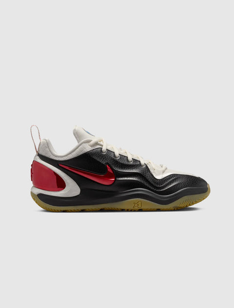Low-top black and white sneaker with red Nike swoosh, gum sole, and textured details