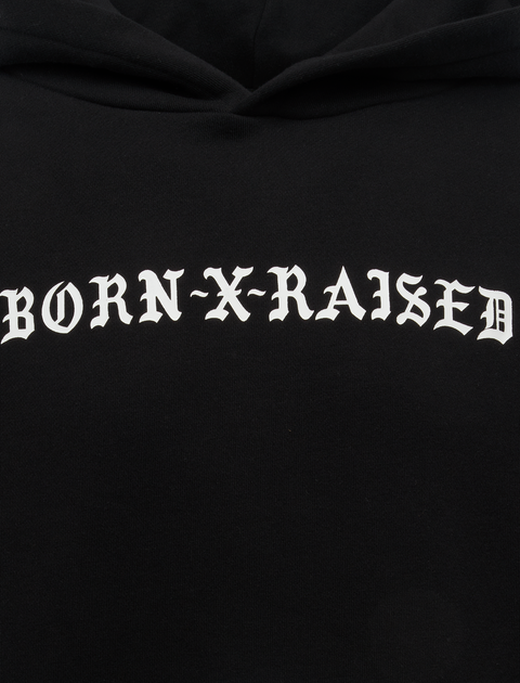 Black hoodie with white gothic 'Born X Raised' text on chest, men's streetwear apparel.