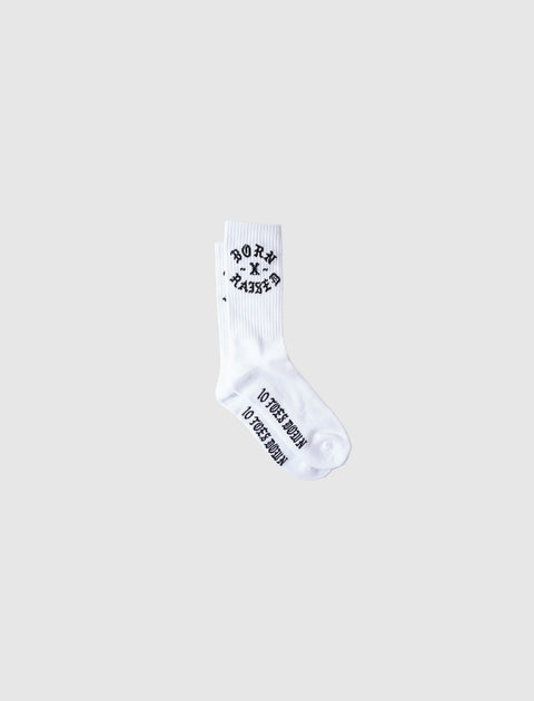 White crew socks with black Born X Raised text and graphics, isolated on light background