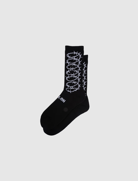 Black crew socks with white barbed wire graphic and text detail on side, streetwear style