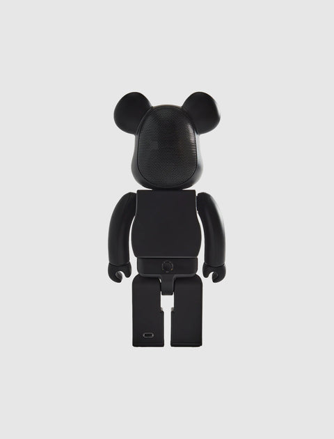 Black bear-shaped collectible toy figure with a perforated face, shown on a white background