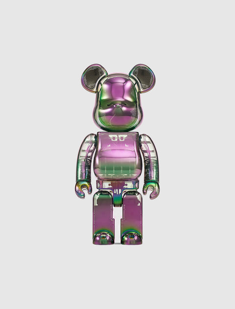 Iridescent bear-shaped collectible art toy with metallic green and purple finish on white background