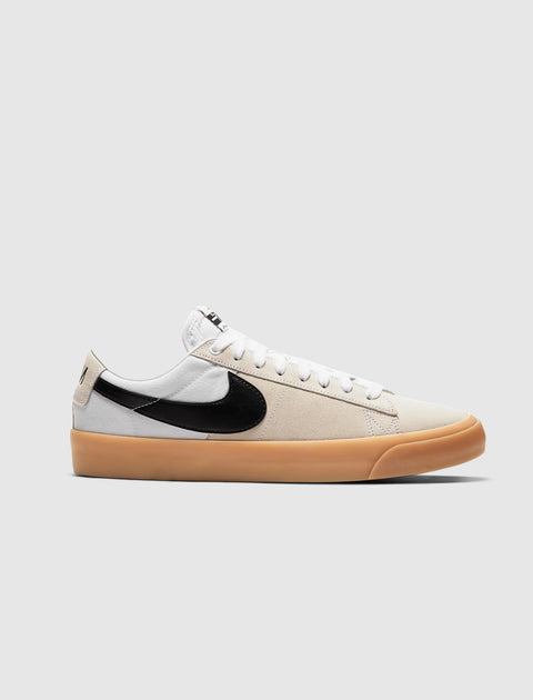 White and beige low-top sneaker with black swoosh logo and gum rubber sole on a plain background