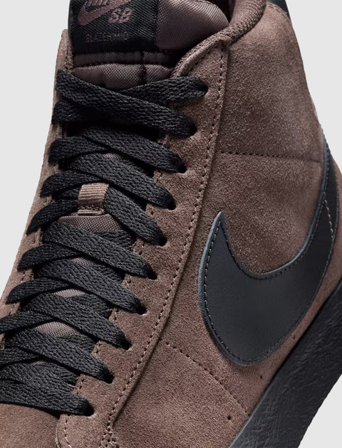Close-up of brown suede high-top sneaker with black swoosh and black laces