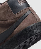 Close-up of a brown suede and black leather sneaker heel with textured black sole
