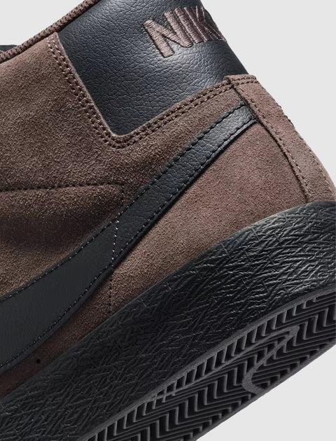 Close-up of a brown suede and black leather sneaker heel with textured black sole