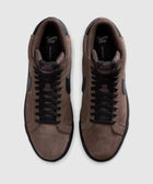 Pair of brown suede low-top sneakers with black laces and black swoosh logo, top view