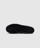 Black sneaker sole with herringbone tread pattern on a light gray background
