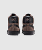Back view of brown and black Nike suede high-top sneakers on white background