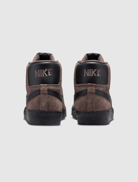 Back view of brown and black Nike suede high-top sneakers on white background